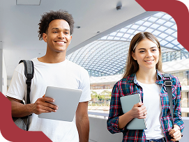Dois estudantes universitários sorrindo, com mochilas e tablets, caminhando em um ambiente acadêmico moderno.
