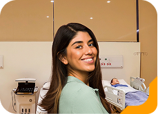 Estudante universitária sorrindo, usando óculos e jaqueta jeans, na Unidade de Ensino Einstein.
