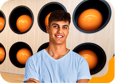 Estudante universitário sorrindo, usando camiseta vinho, no laboratório de Fisioterapia da Unidade de Ensino Einstein.