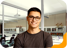 Estudante universitário sorrindo, usando camiseta verde, no laboratório da Unidade de Ensino Einstein.
