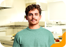 Estudante universitária sorrindo, usando jaqueta cinza, na Unidade de Ensino Einstein.