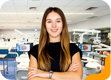 Estudante universitária sorrindo, usando camiseta verde, no laboratório de Odontologia da Unidade de Ensino Einstein.
