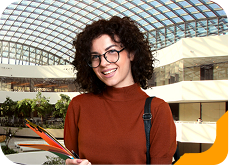 Estudante universitário sorrindo, usando blusa azul com zíper, na Unidade de Ensino Einstein.