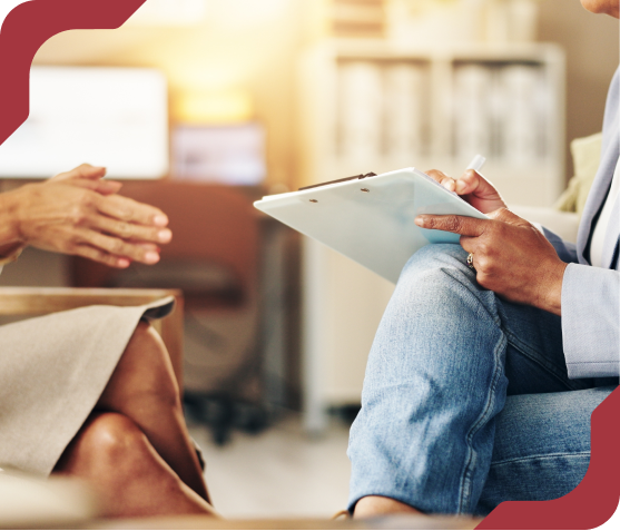 Estudante de psicologia tomando notas em uma prancheta durante uma conversa.