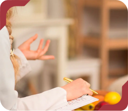 Estudante de nutrição tomando notas em uma prancheta durante uma aula.