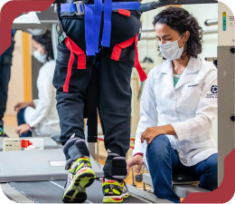 Fisioterapeuta do Einstein supervisionando paciente em reabilitação de marcha em esteira.