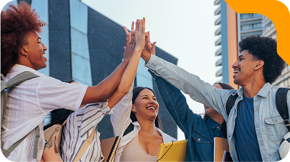 Grupo de estudantes universitários felizes comemorando com um high five.
